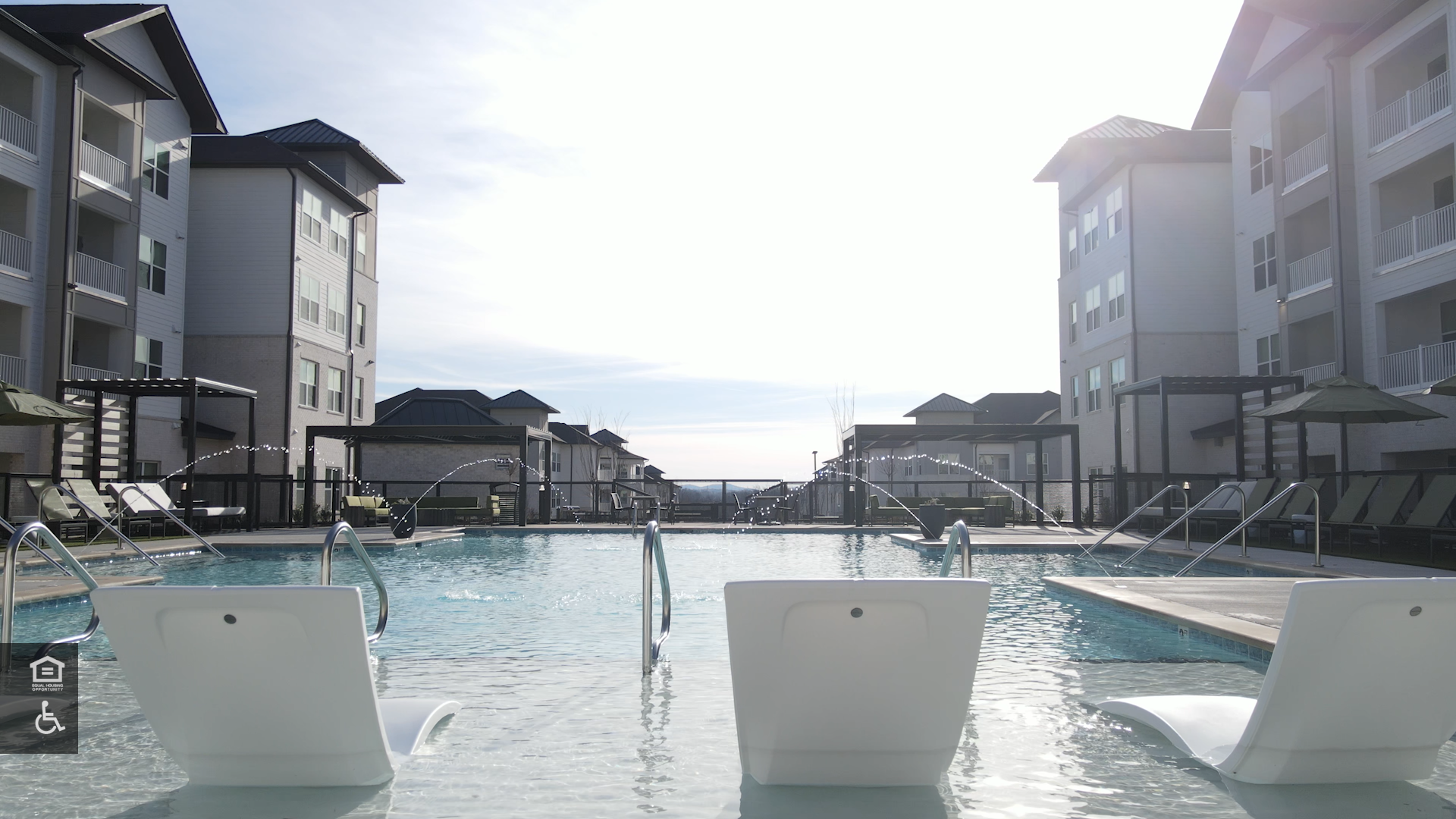 Lounging chairs sit in the shallow end of the luxury, salt-water pool at The Ravelle apartment community.