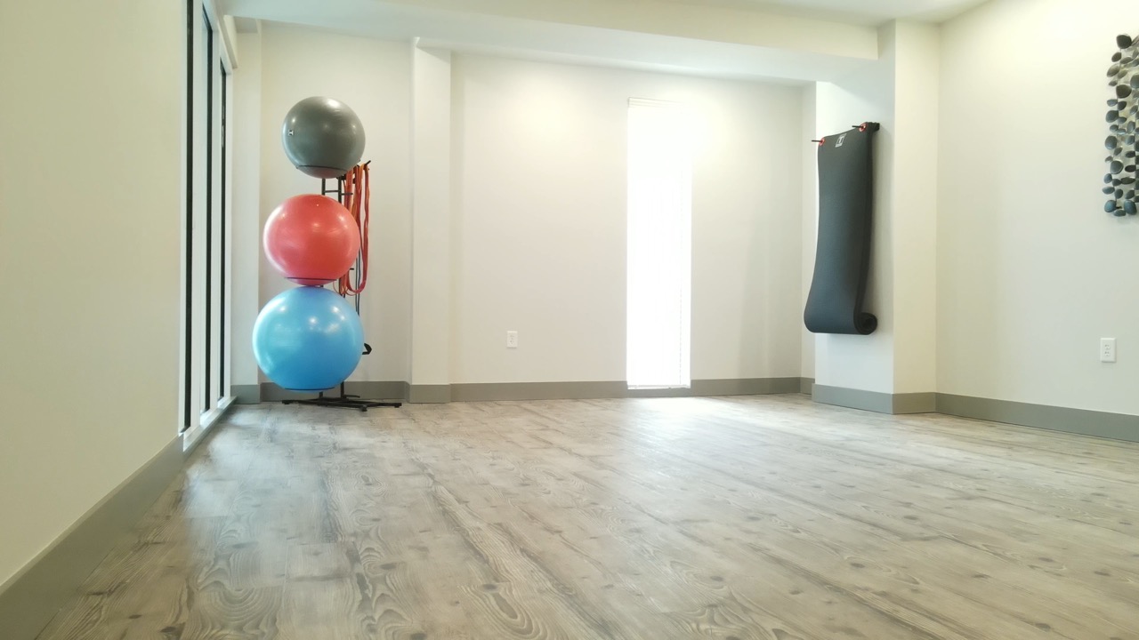 Yoga studio with mirror wall and bright windows at The Ravelle at Ridgeview Apartment Community in Nashville, TN