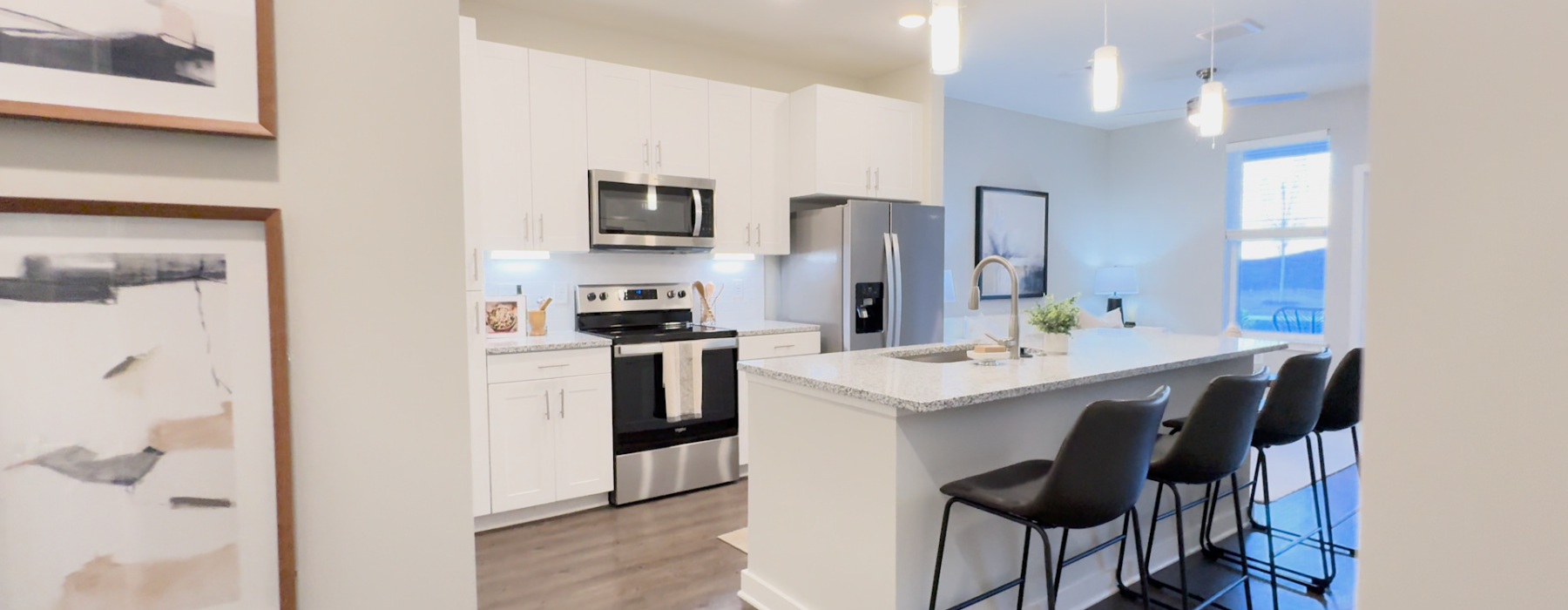 Interior view of the kitchen and living area of the POINTE 1B/1B Apartment Home.