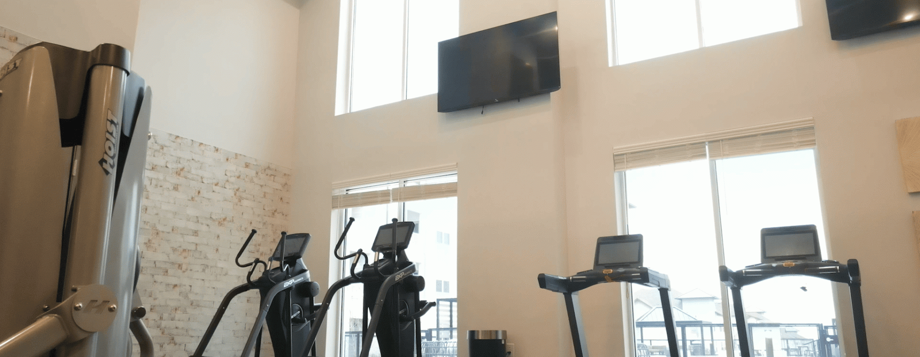 Tread Mills and Elliptical Machines line the wall in the two story fitness center at The Ravelle.