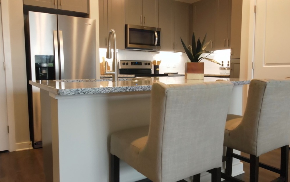 Modern kitchen in the Vista apartment home at The Ravelle in Nashville with stainless steel appliances and granite island