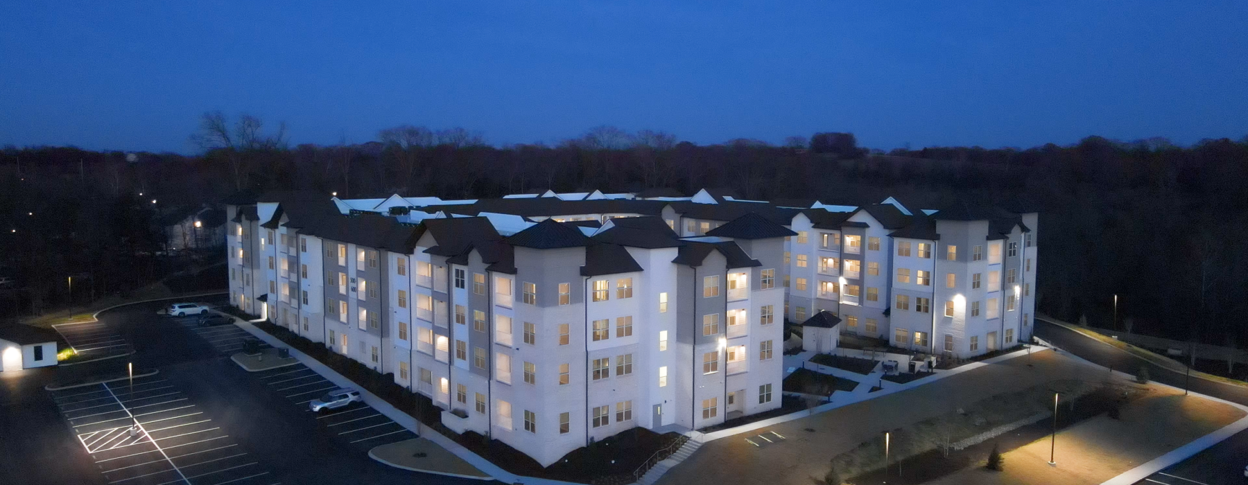 Evening aerial view of the signature, three story high rise building at the Ravelle at Ridgeview.