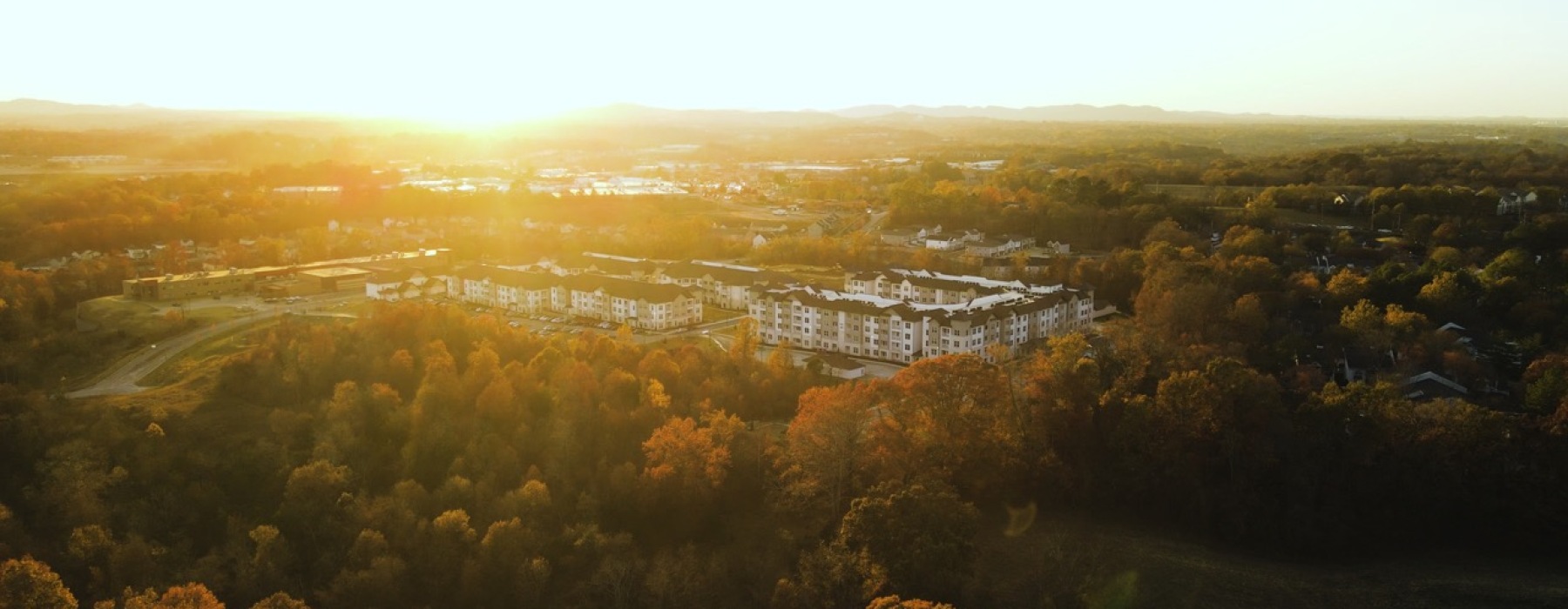 Aerial view of The Ravelle at Ridgeview apartment community in Southeast Nashville. The sun is setting behind the Tennessee hills.